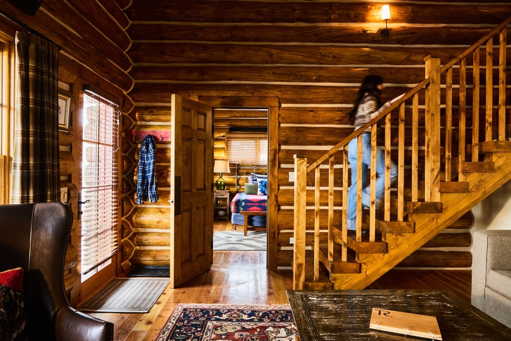 A woman walking up the stairs of a cabin at Turpin Meadow Ranch.